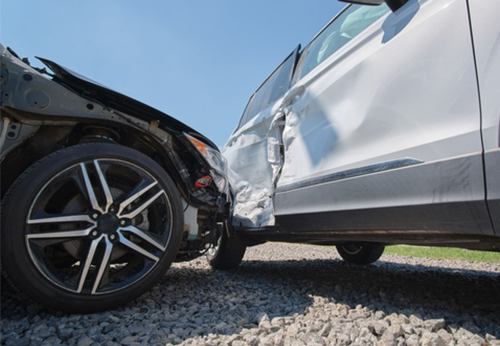 Low-angle photo of two heavily damaged cars after a head-on collision, illustrating Car Accidents in Davie, FL.