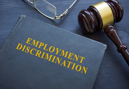 Employment Discrimination law book with gavel and glasses; representing workplace legal rights.