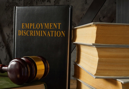Employment Discrimination book with gavel and stack of law volumes; workplace legal resources.