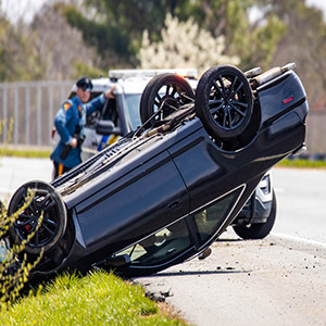 Overturned car after Florida rollover crash, showing severe accident scene and emergency response aftermath.